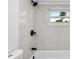 Modern bathroom features neutral tile, updated fixtures, and a window letting in natural light at 9831 Scenic Dr, Port Richey, FL 34668