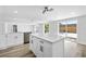 Bright kitchen with white cabinets, stone countertops, an island, and stainless steel appliances at 9831 Scenic Dr, Port Richey, FL 34668