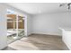 Open-concept room featuring light colored laminate flooring and sliding glass doors to the backyard at 9831 Scenic Dr, Port Richey, FL 34668