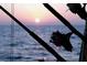 Fishing rods silhouetted against the backdrop of a vibrant sunset over the tranquil ocean waters at 9831 Scenic Dr, Port Richey, FL 34668