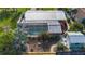 Aerial view of backyard with pool, screened in patio, garden with flowers, and patio seating, creating a private outdoor space at 9929 Bay Dr, Gibsonton, FL 33534