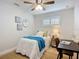 Bedroom featuring bright white trim and walls, desk, ceiling fan and decor at 9929 Bay Dr, Gibsonton, FL 33534