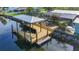 Aerial view of a private covered boat dock with ladder, located on a waterfront canal, perfect for boating and enjoying the water at 9929 Bay Dr, Gibsonton, FL 33534