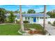 Charming single-story home with a well-manicured lawn and a bright blue front door beneath a new metal roof at 9929 Bay Dr, Gibsonton, FL 33534