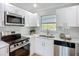 Well-appointed kitchen with stainless steel appliances, white cabinetry, and modern lighting, perfect for culinary enthusiasts at 9929 Bay Dr, Gibsonton, FL 33534