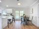 Bright kitchen and dining area with white cabinets, hardwood floors, and views of the outdoor pool at 9929 Bay Dr, Gibsonton, FL 33534