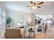 Bright and airy living room with hardwood floors, modern furnishings, and a ceiling fan with a view to the kitchen at 9929 Bay Dr, Gibsonton, FL 33534