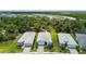 Aerial view of three homes highlighting well-maintained lawns, neutral paint, and lush greenery at 10036 Beachwalk Dr, Englewood, FL 34223