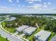 Wide aerial view showcasing a residential neighborhood surrounded by trees, lakes, and community amenities at 10036 Beachwalk Dr, Englewood, FL 34223