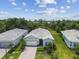 Aerial view of a new home featuring a meticulously landscaped yard in a quiet, wooded neighborhood at 10036 Beachwalk Dr, Englewood, FL 34223
