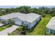 Aerial shot of a single Gathering home boasting a well-manicured lawn, tidy landscaping, and a tile roof at 10036 Beachwalk Dr, Englewood, FL 34223