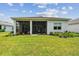 Exterior view of the home highlighting the screened-in lanai and beautifully landscaped backyard at 10036 Beachwalk Dr, Englewood, FL 34223