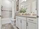 Bright bathroom featuring a shower over tub, modern fixtures, and a decorative patterned rug at 10036 Beachwalk Dr, Englewood, FL 34223
