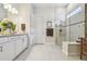 Modern bathroom featuring a glass shower, white vanity, and neutral tile flooring at 10036 Beachwalk Dr, Englewood, FL 34223
