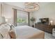 Inviting bedroom with soft lighting, king-sized bed and views of a lush green outside at 10036 Beachwalk Dr, Englewood, FL 34223