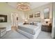 Relaxing bedroom with neutral tones, king bed, art and a bright chandelier at 10036 Beachwalk Dr, Englewood, FL 34223