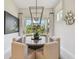 Cozy dining area featuring stylish lighting fixture, round table, and scenic backyard view at 10036 Beachwalk Dr, Englewood, FL 34223