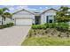 Charming single-story home with well-manicured landscaping, a paver driveway, and a bright, welcoming facade at 10036 Beachwalk Dr, Englewood, FL 34223