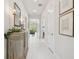 Bright hallway with white tile floors leading to the living area, with elegant decorations and art at 10036 Beachwalk Dr, Englewood, FL 34223