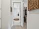 Hallway leading to closet and bathroom, with neutral tones and carpeted floors at 10036 Beachwalk Dr, Englewood, FL 34223