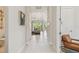 Bright hallway with white tile floors leading to a cozy living room view and elegant furnishings at 10036 Beachwalk Dr, Englewood, FL 34223