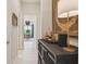 Hallway with neutral walls leading to a living space with an ornate cabinet and table lamp at 10036 Beachwalk Dr, Englewood, FL 34223