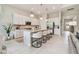 Modern kitchen with an island and seating for four, complemented by pendant lighting and white cabinetry at 10036 Beachwalk Dr, Englewood, FL 34223