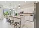 Modern kitchen featuring a large center island with seating, stylish pendant lighting, and stainless appliances at 10036 Beachwalk Dr, Englewood, FL 34223