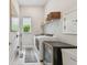 Laundry room featuring white appliances, a utility sink, and overhead shelving at 10036 Beachwalk Dr, Englewood, FL 34223