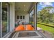 Covered patio featuring modern furniture, neutral decor, and views of the landscaped backyard and natural preserve at 10036 Beachwalk Dr, Englewood, FL 34223