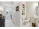 Hallway view of powder room featuring a pedestal sink, toilet, and decorative wall art at 10036 Beachwalk Dr, Englewood, FL 34223