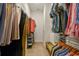 Walk-in closet with ample storage and shelving, bench seating, and neutral carpet flooring at 10036 Beachwalk Dr, Englewood, FL 34223