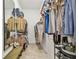 Walk-in closet with ample storage and shelving, bench seating, and neutral carpet flooring at 10036 Beachwalk Dr, Englewood, FL 34223