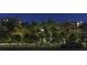 Stunning condo at night with lush landscaping, palm trees, and manicured entryway at 1028 Sunset Point Rd # R4, Clearwater, FL 33755