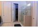 Modern bathroom with a glass-enclosed shower, tile floors, and a linen closet at 10431 Alcon Blue Dr, Riverview, FL 33578
