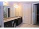 Bathroom featuring granite countertops, double sinks, and a large mirror at 10431 Alcon Blue Dr, Riverview, FL 33578