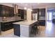 Modern kitchen featuring dark cabinets, granite countertops, and stainless steel appliances at 10431 Alcon Blue Dr, Riverview, FL 33578