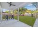 Spacious backyard features an outdoor patio with ceiling fan, seating and new wooden fence at 1052 55Th N Ave, St Petersburg, FL 33703
