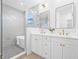 Bright bathroom featuring a modern bathtub, dual sinks with gold fixtures, and a glass-enclosed shower at 1052 55Th N Ave, St Petersburg, FL 33703