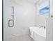 Bright bathroom featuring a freestanding tub, marble-style tiling, gold hardware, and a glass shower at 1052 55Th N Ave, St Petersburg, FL 33703