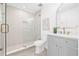 Bright bathroom featuring a glass shower, modern vanity with gold fixtures and neutral color palette at 1052 55Th N Ave, St Petersburg, FL 33703