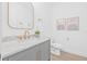 This stylish powder room includes a marble countertop, gold fixtures and framed art at 1052 55Th N Ave, St Petersburg, FL 33703