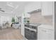 Well-lit kitchen with stainless steel oven, white cabinetry, and an open layout to the living room at 1052 55Th N Ave, St Petersburg, FL 33703