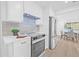 A bright, white kitchen featuring stainless steel appliances, white cabinets and an adjoining dining area at 1052 55Th N Ave, St Petersburg, FL 33703