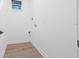Clean laundry room with vinyl wood-look floors, utility hookups and neutral paint at 1052 55Th N Ave, St Petersburg, FL 33703