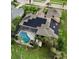 Aerial view of a house with solar panels and a screened in pool at 10532 Cory Lake Dr, Tampa, FL 33647