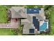 Aerial view of the home, highlighting the solar panels, pool, red car, and well-maintained landscaping at 10532 Cory Lake Dr, Tampa, FL 33647