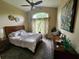 A bright bedroom featuring a large window, ceiling fan and earth tone decor at 10532 Cory Lake Dr, Tampa, FL 33647