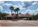Community entrance featuring palm trees, a red tiled roof, and a gated entrance at 10532 Cory Lake Dr, Tampa, FL 33647