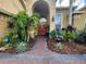 Beautiful front entrance with a red double door and lush tropical landscaping at 10532 Cory Lake Dr, Tampa, FL 33647